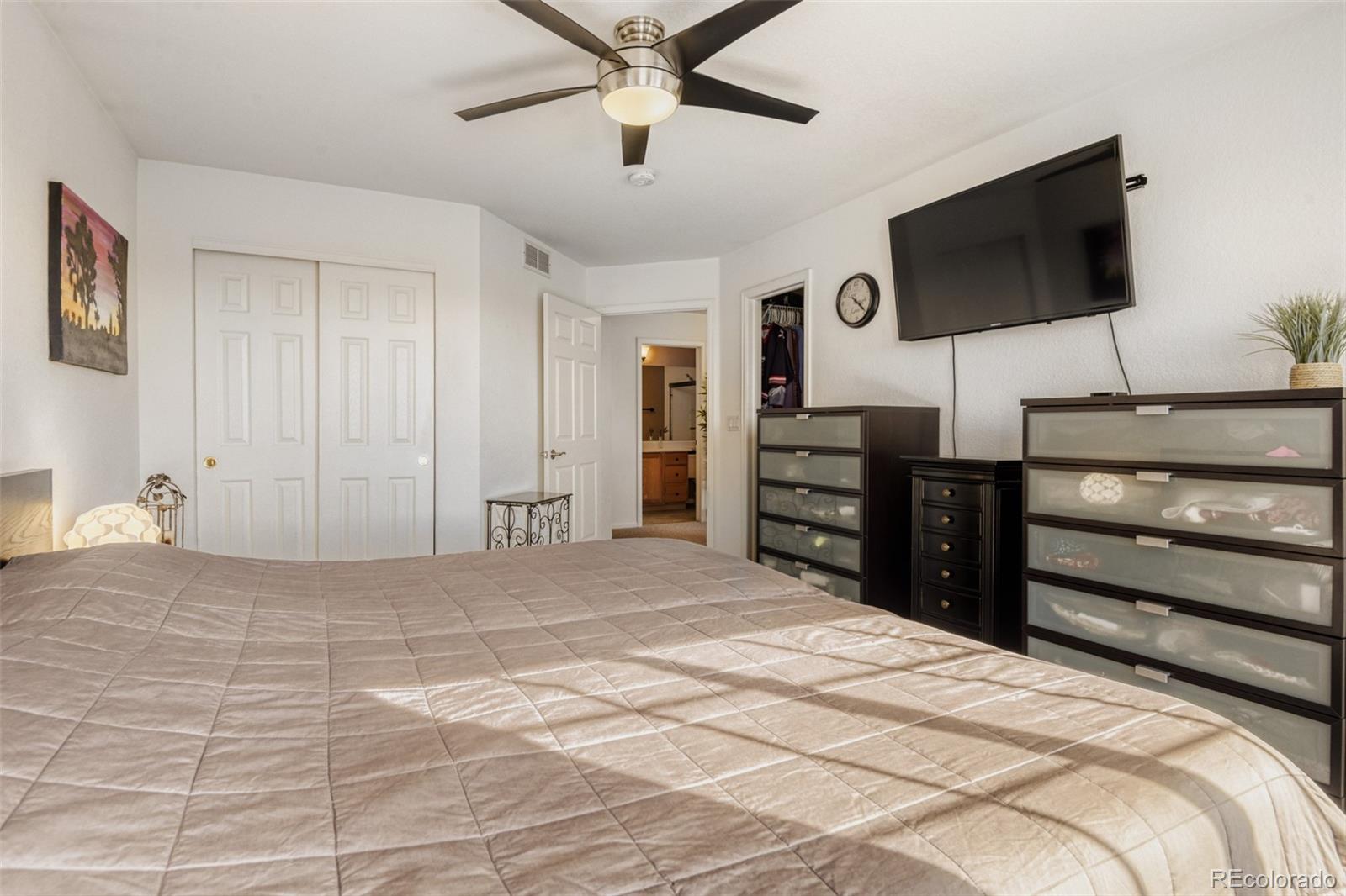 9649 Adelaide Circle Highlands Ranch, CO 80130 - Photo 18 of 32 a bedroom with a bed and a flat screen tv