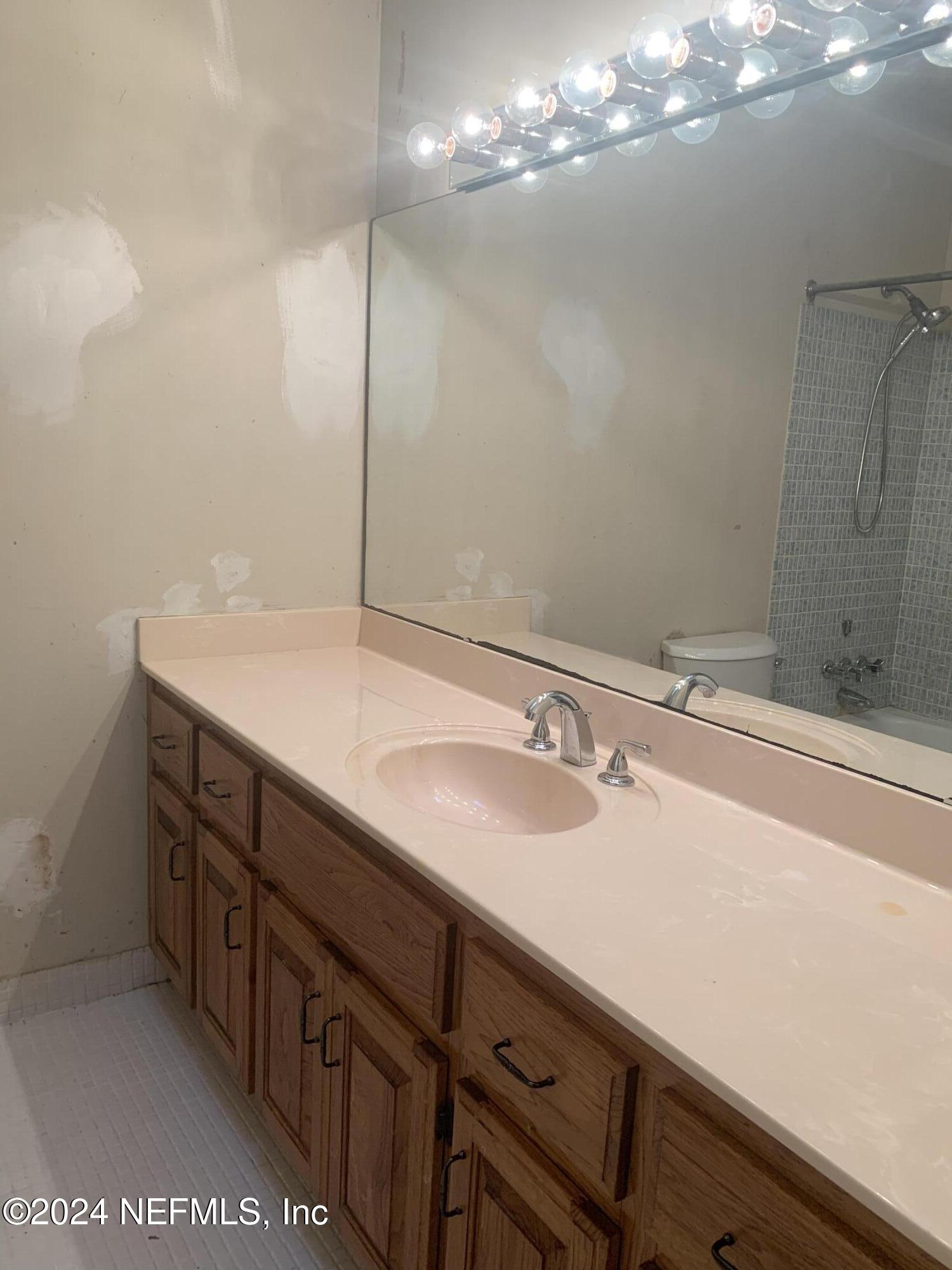 10558 Tulsa Road Jacksonville, FL 32218 - Photo 11 of 24 a bathroom with a sink and a mirror