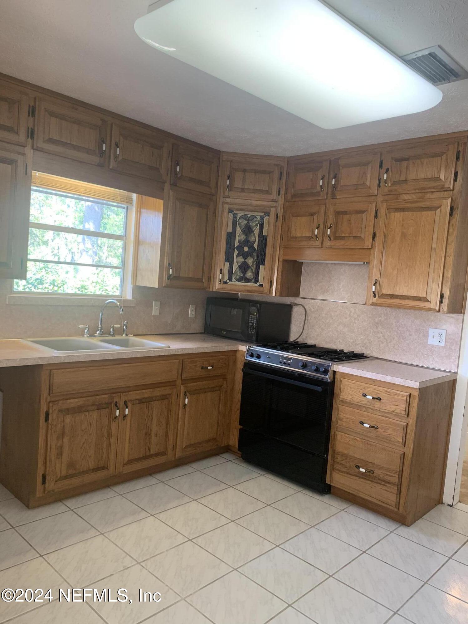 10558 Tulsa Road Jacksonville, FL 32218 - Photo 16 of 24 a kitchen with stainless steel appliances granite countertop a sink and cabinets