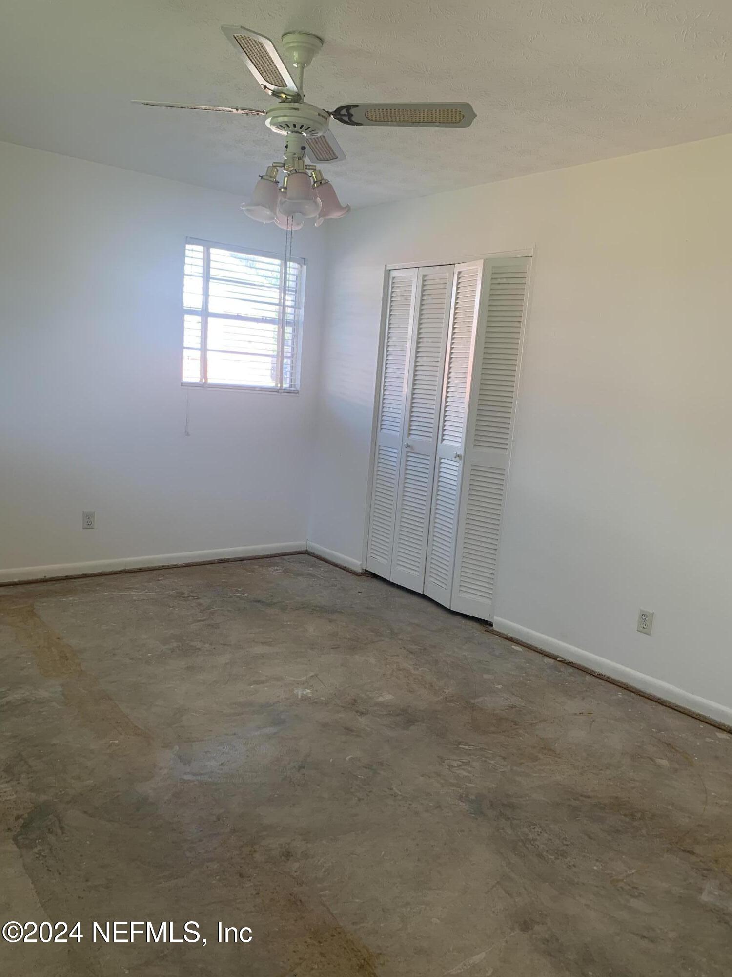 10558 Tulsa Road Jacksonville, FL 32218 - Photo 6 of 24 an empty room with windows and fan