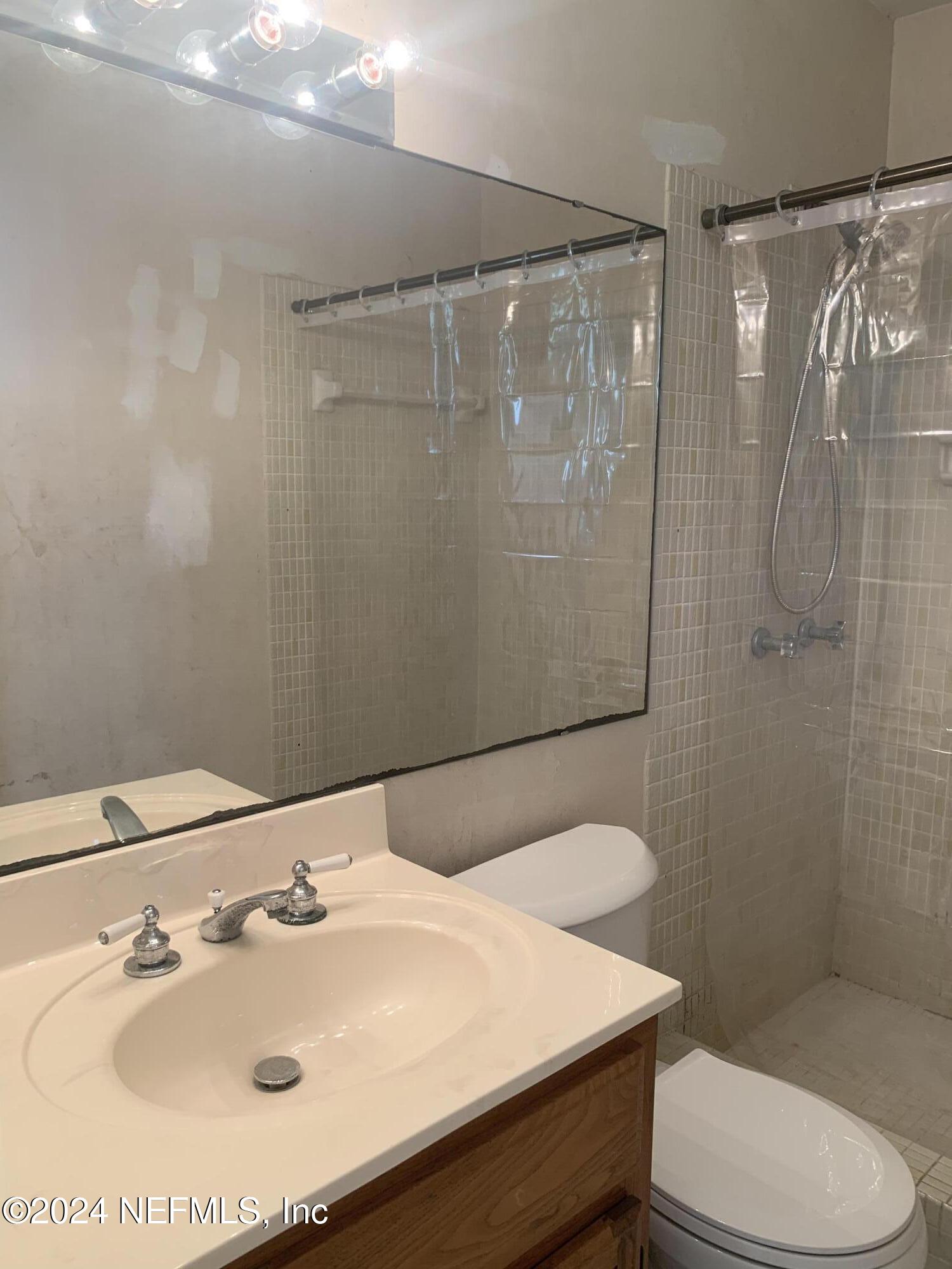 10558 Tulsa Road Jacksonville, FL 32218 - Photo 7 of 24 a bathroom with a sink toilet and shower