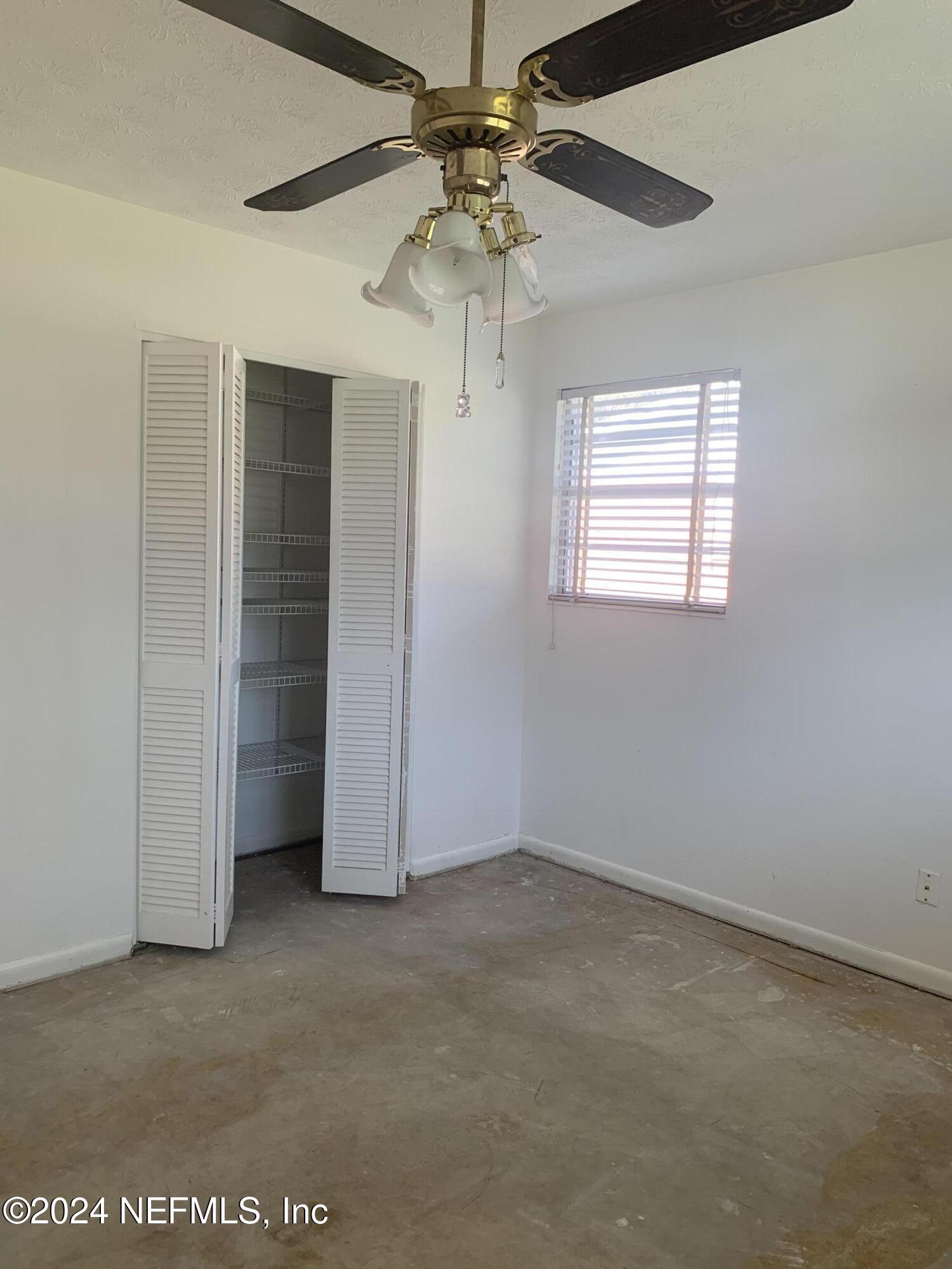 10558 Tulsa Road Jacksonville, FL 32218 - Photo 8 of 24 an empty room with a ceiling fan and a window
