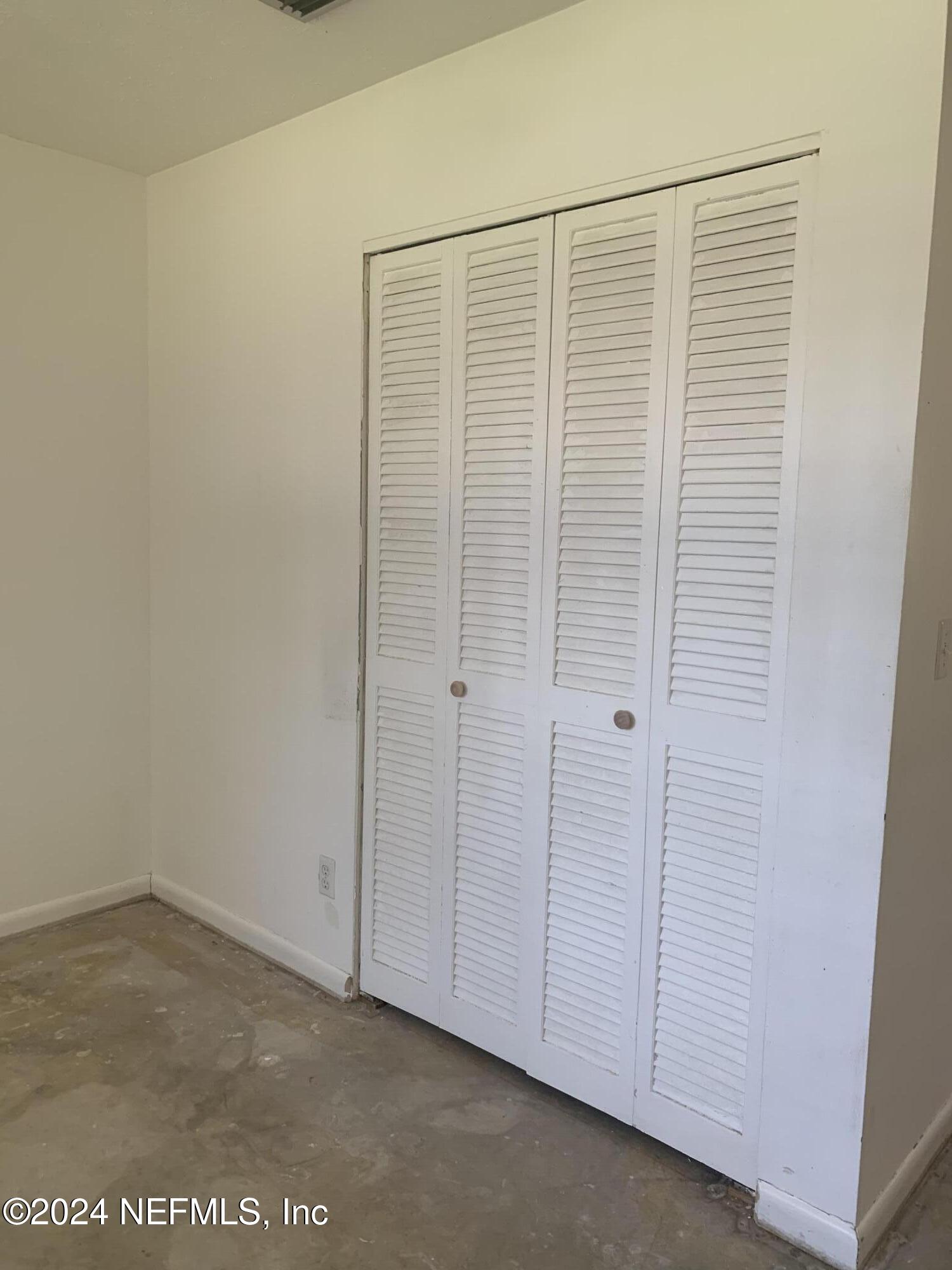10558 Tulsa Road Jacksonville, FL 32218 - Photo 10 of 24 an empty room with a wooden door