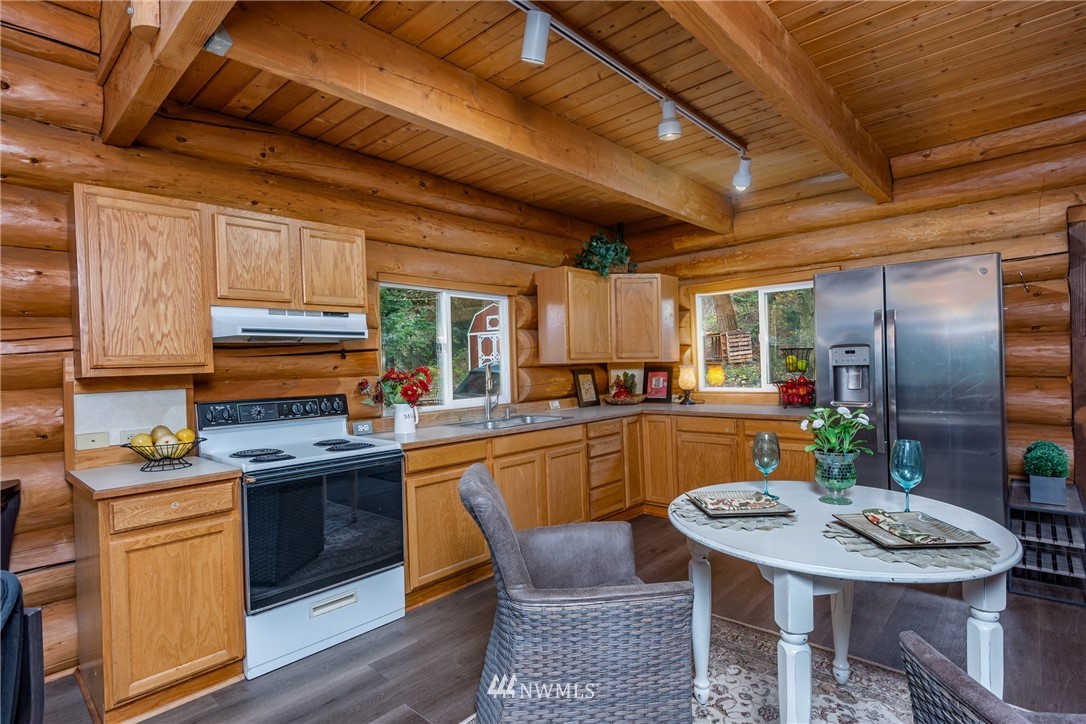 5720 Cameron Road Freeland, WA 98249 - Photo 12 of 36 a kitchen with stainless steel appliances granite countertop a sink a stove a refrigerator cabinets and chairs