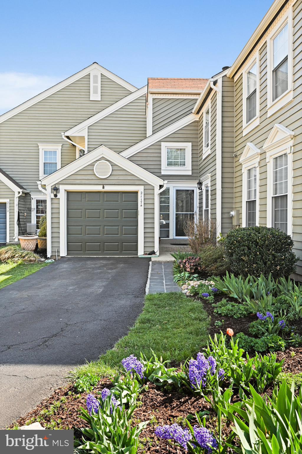 a front view of a house with a garden and flowers