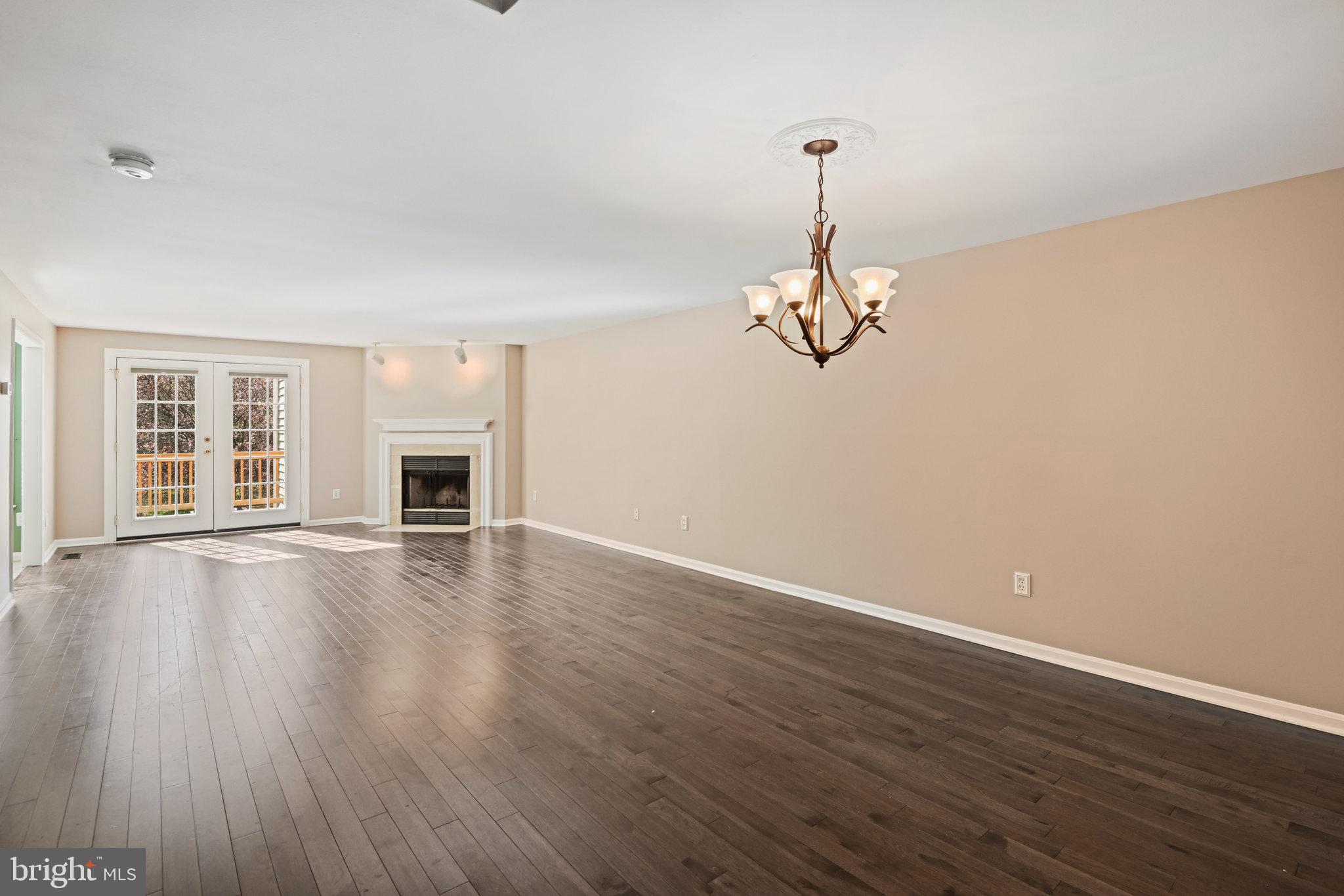 21174 Wildflower Square Ashburn, VA 20147 - Photo 4 of 30 a view of empty room with wooden floor and fireplace