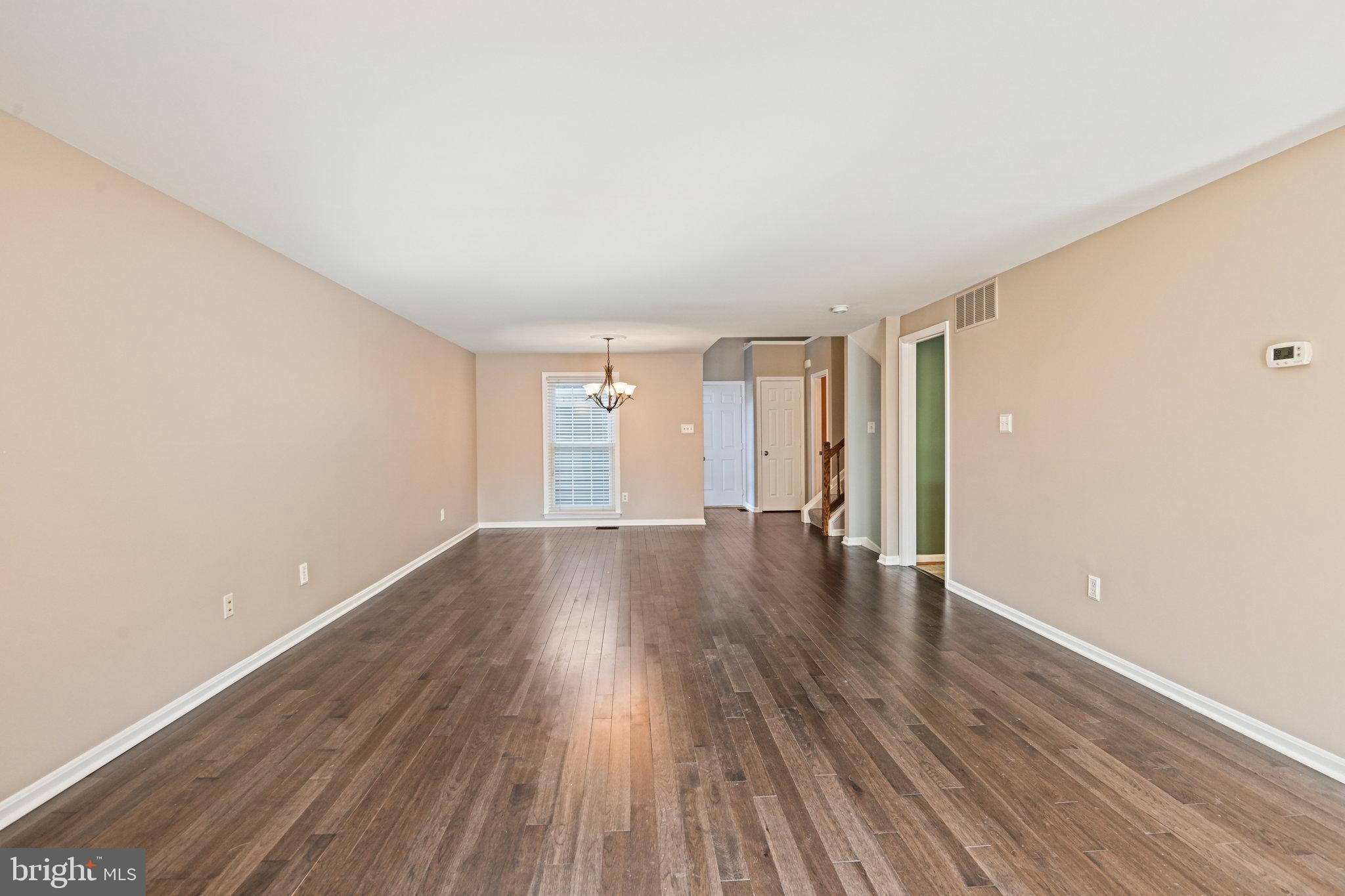 21174 Wildflower Square Ashburn, VA 20147 - Photo 6 of 30 a view of an empty room with wooden floor and window