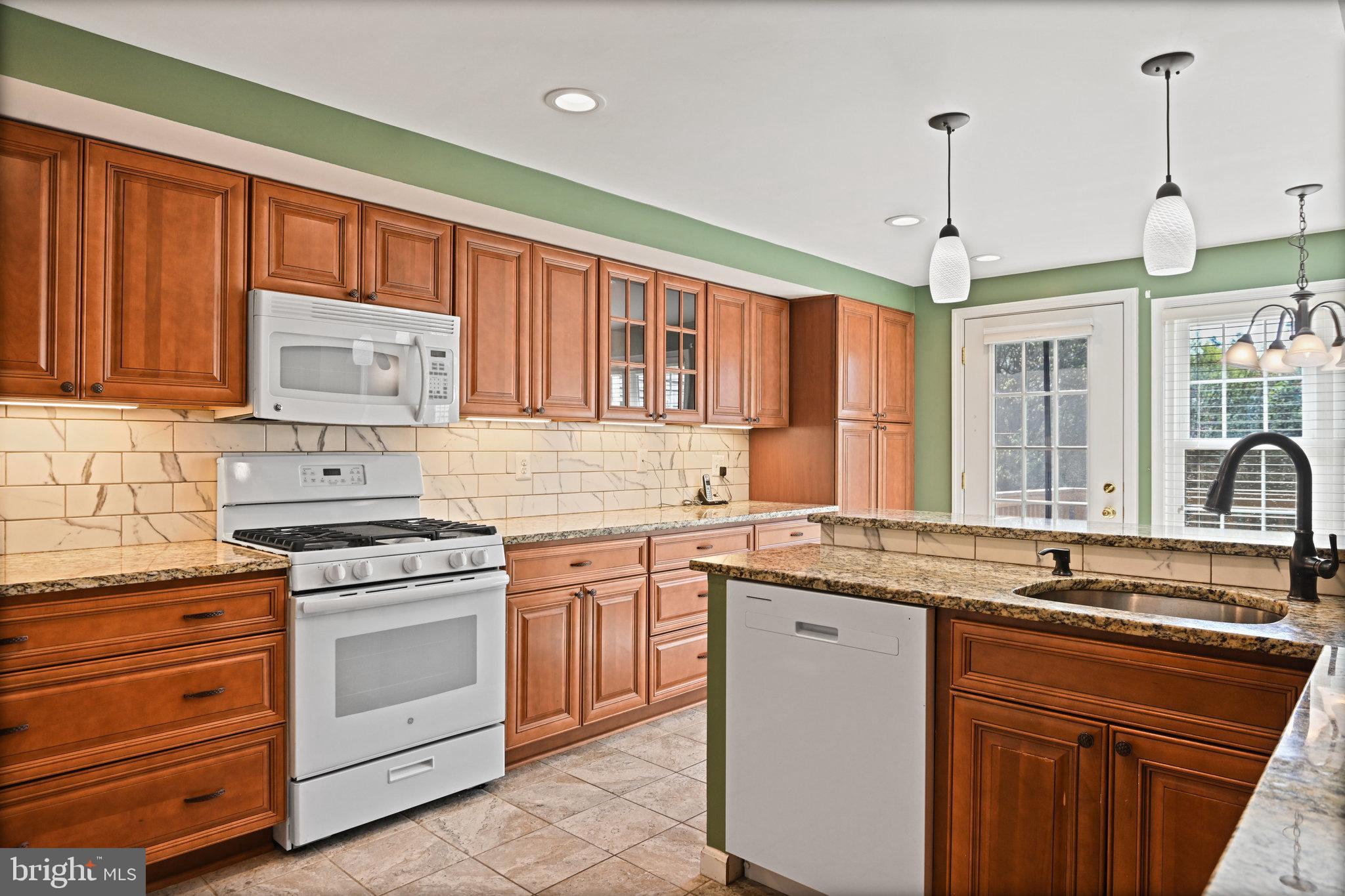 21174 Wildflower Square Ashburn, VA 20147 - Photo 7 of 30 a kitchen with stainless steel appliances granite countertop a sink stove and refrigerator