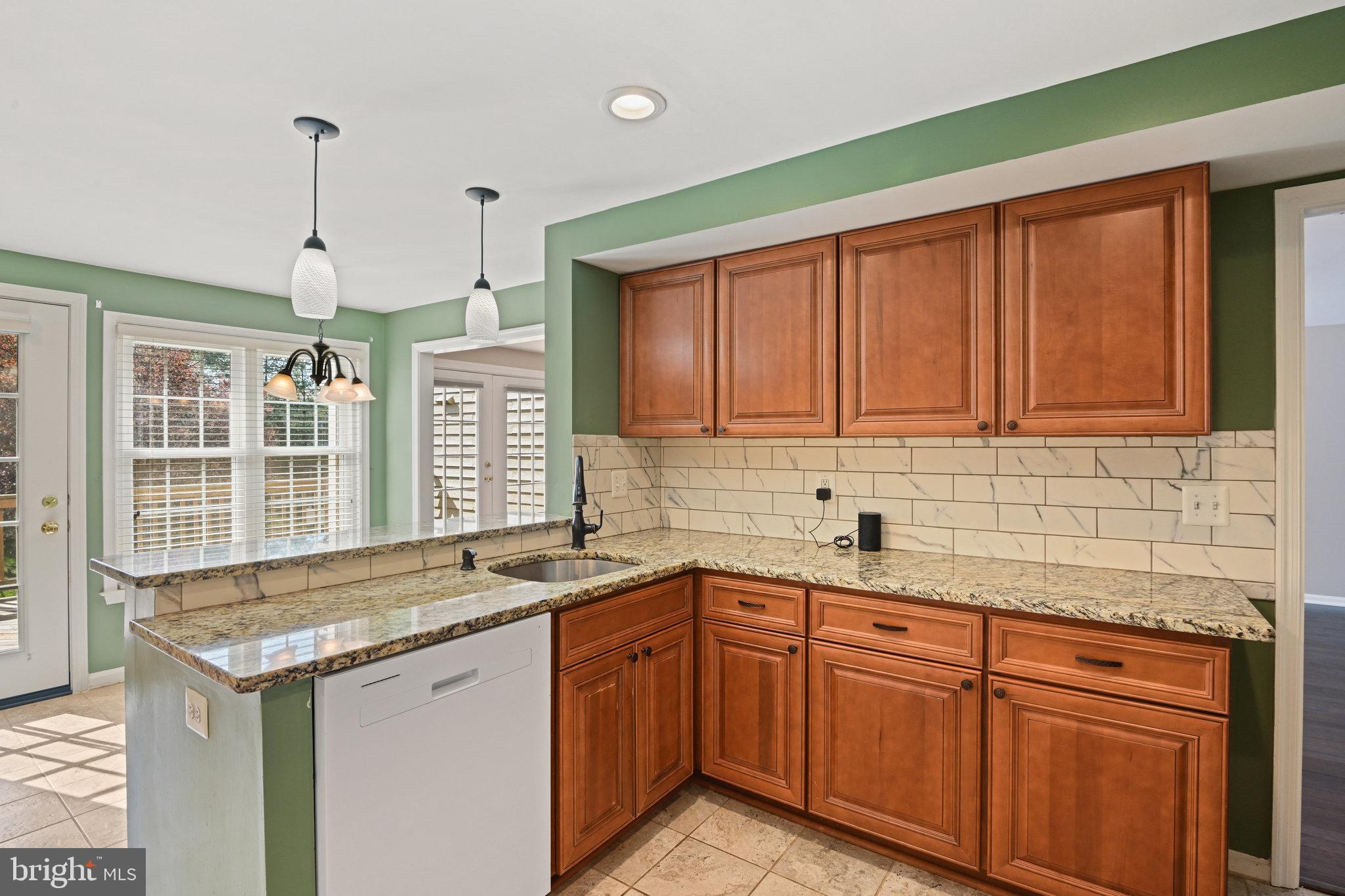 21174 Wildflower Square Ashburn, VA 20147 - Photo 9 of 30 a kitchen with granite countertop sink stove and cabinets