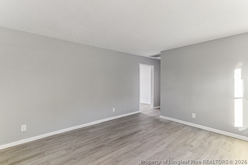 922 Rancho Drive Fayetteville, NC 28303 - Photo 8 of 21 a view of an empty room with wooden floor and a window