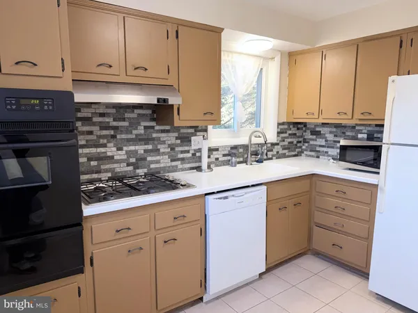 a kitchen with white cabinets and appliances