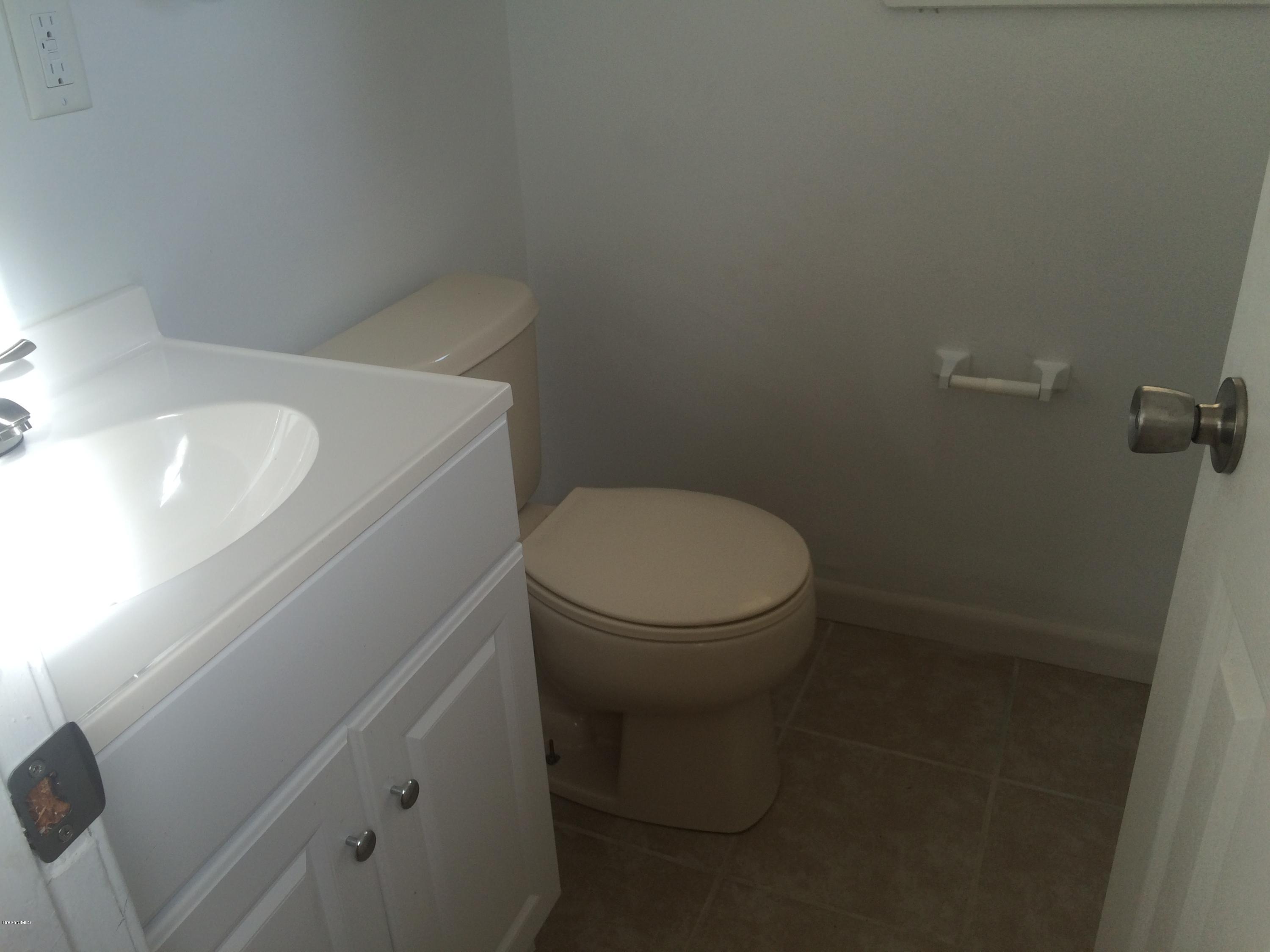 1040 Hickory Lane Cocoa, FL 32922 - Photo 14 of 17 a white toilet sitting next to a white sink