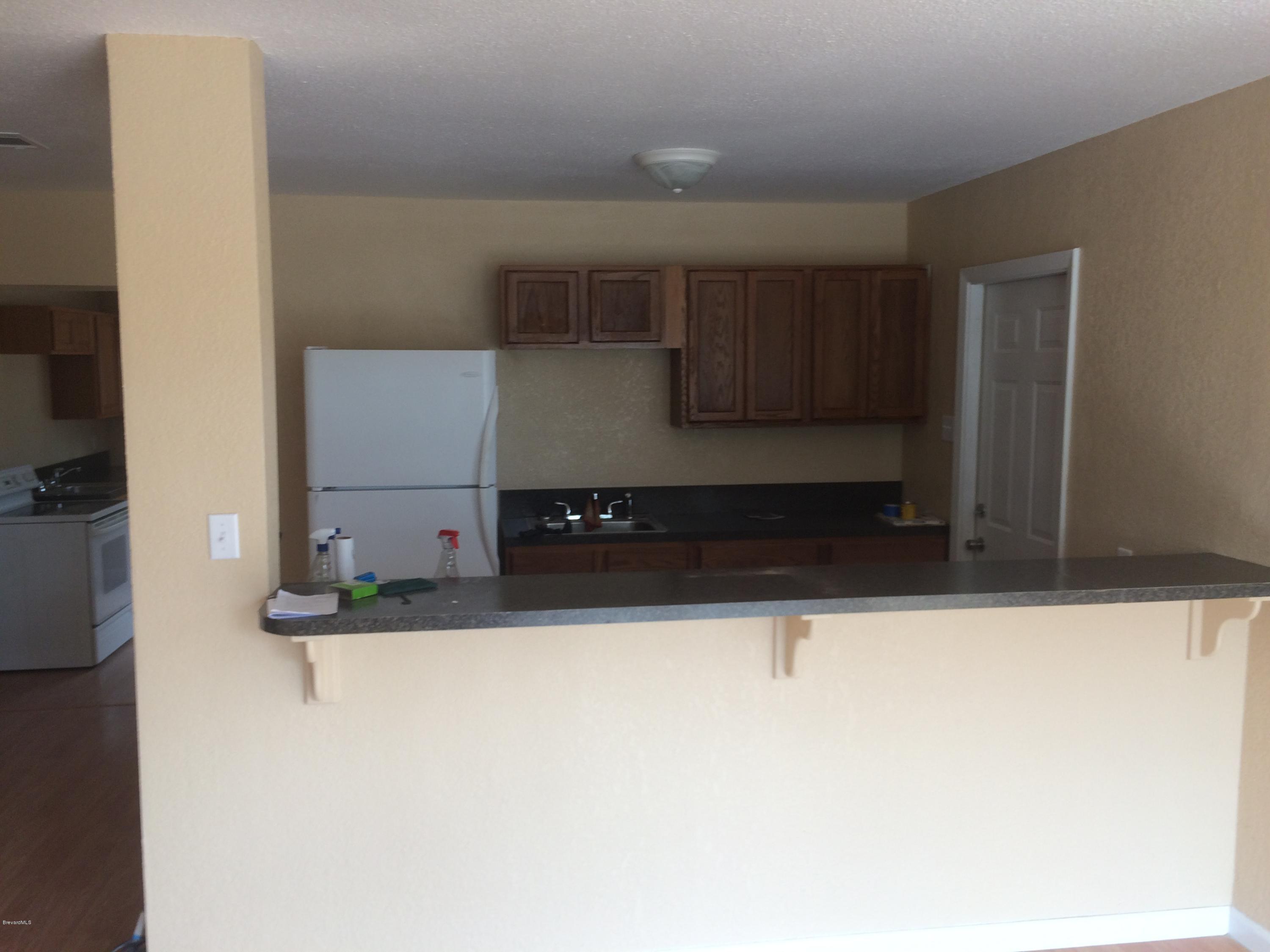 1040 Hickory Lane Cocoa, FL 32922 - Photo 7 of 17 a kitchen with granite countertop a refrigerator and a sink