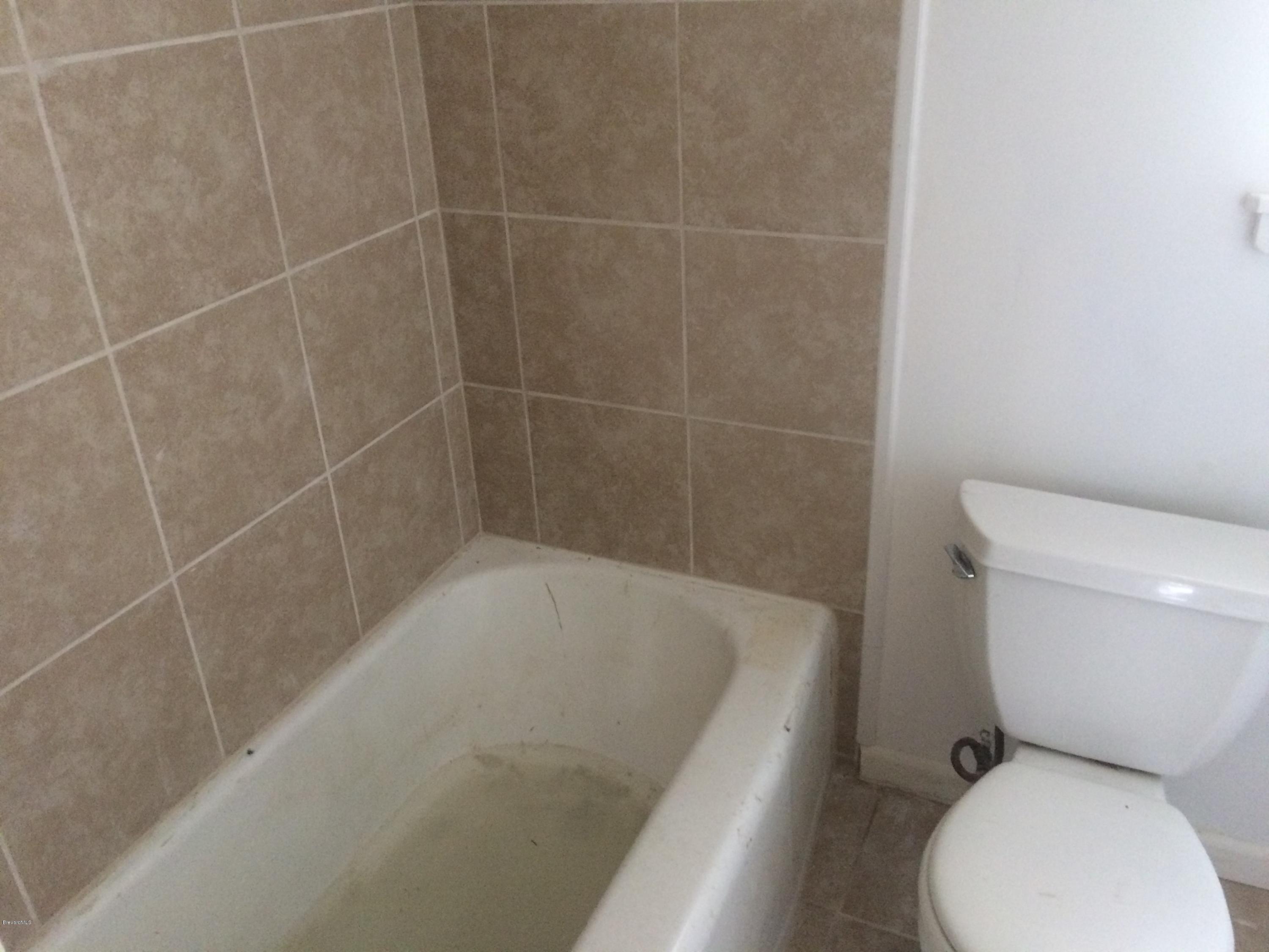 1040 Hickory Lane Cocoa, FL 32922 - Photo 9 of 17 a white toilet sitting next to a bath tub