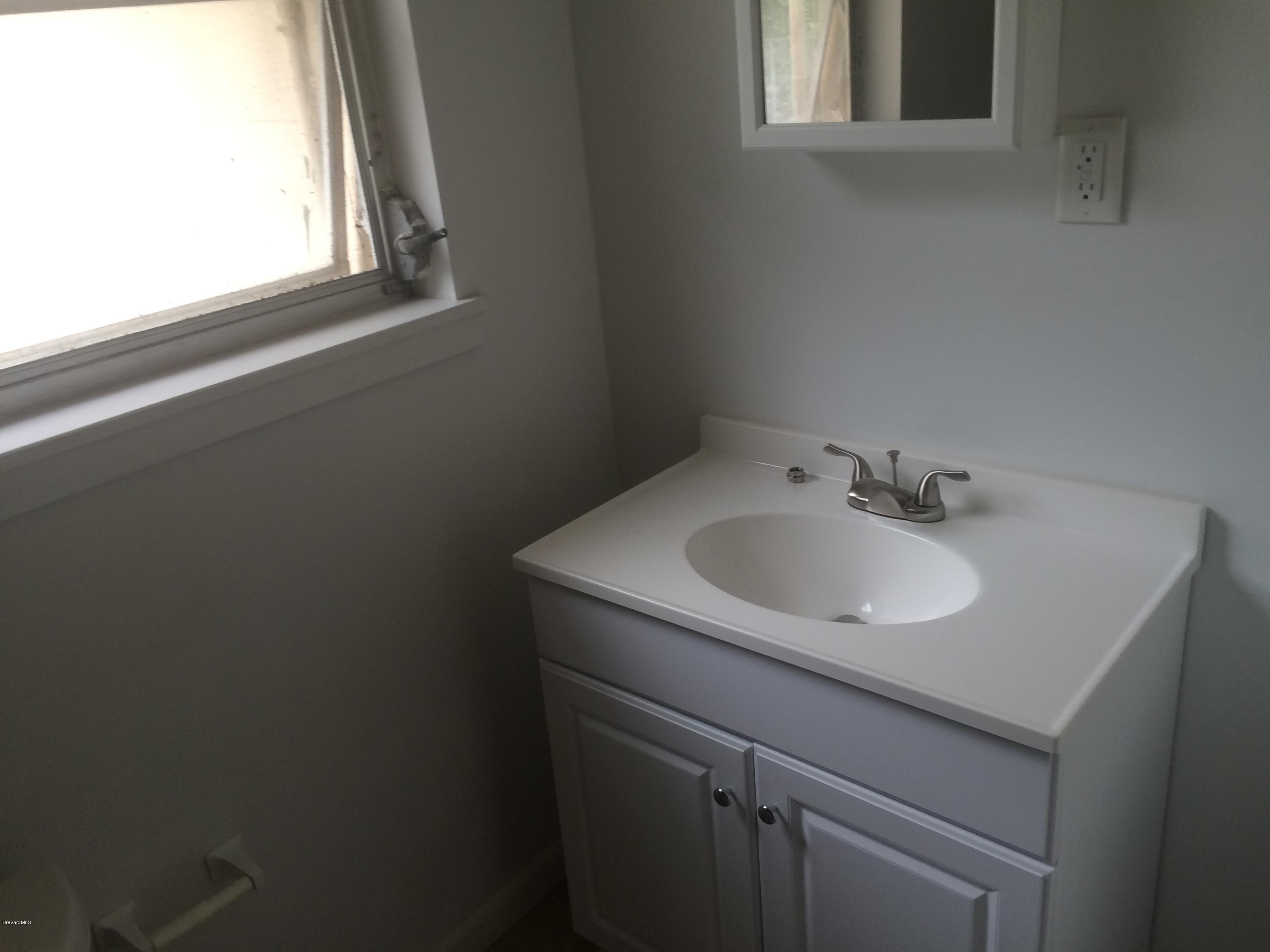 1040 Hickory Lane Cocoa, FL 32922 - Photo 10 of 17 a bathroom with a sink and a window