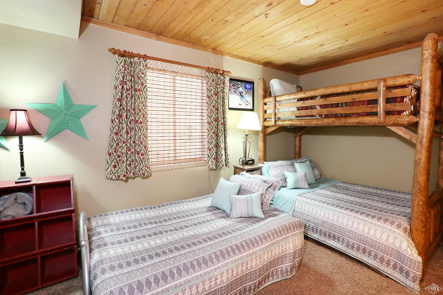 442 South Frontage Road East, Unit B306 Vail, CO 81657 - Photo 14 of 18 a bedroom with two beds and a chandelier
