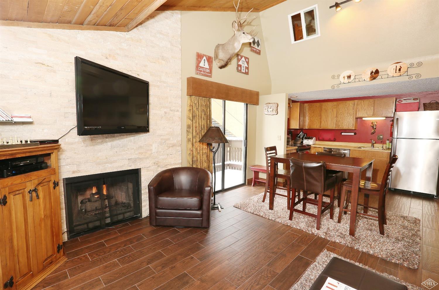 442 South Frontage Road East, Unit B306 Vail, CO 81657 - Photo 3 of 18 a living room with furniture a fireplace and a flat screen tv