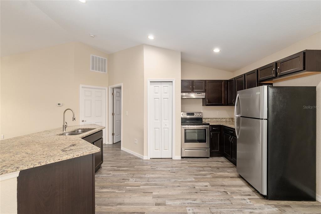 71 Juniper Trail Loop Ocala, FL 34480 - Photo 24 of 58 a kitchen with kitchen island granite countertop a refrigerator oven a sink and dishwasher