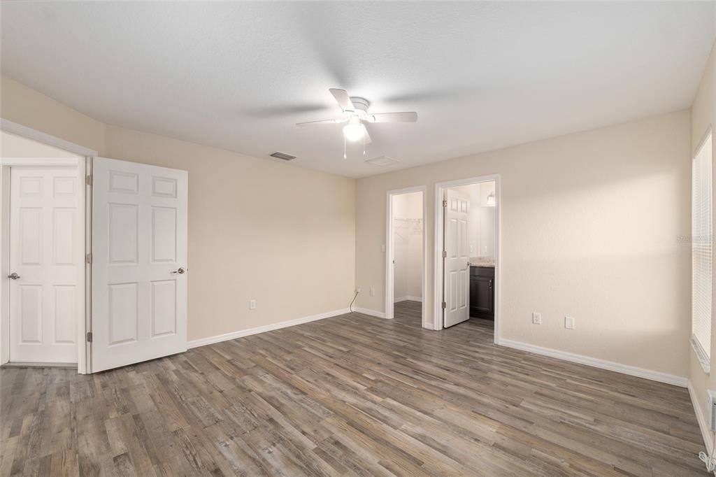71 Juniper Trail Loop Ocala, FL 34480 - Photo 33 of 58 an empty room with wooden floor and ceiling fan