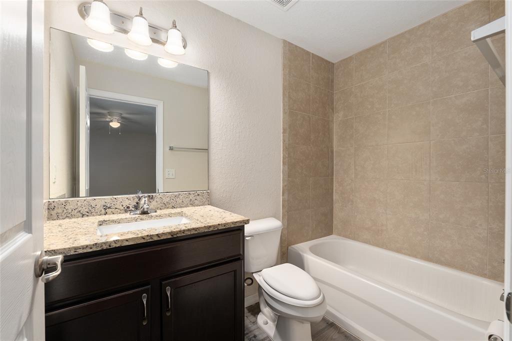 71 Juniper Trail Loop Ocala, FL 34480 - Photo 35 of 58 a bathroom with a granite countertop sink a toilet a mirror and bathtub