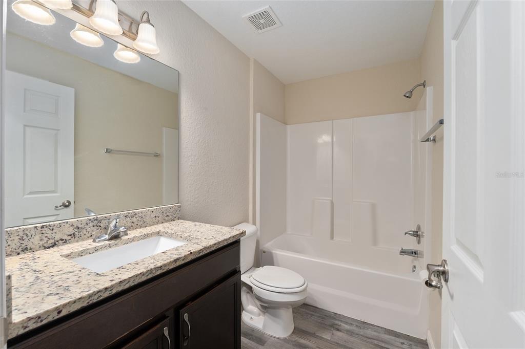 71 Juniper Trail Loop Ocala, FL 34480 - Photo 42 of 58 a bathroom with a granite countertop sink a toilet and shower