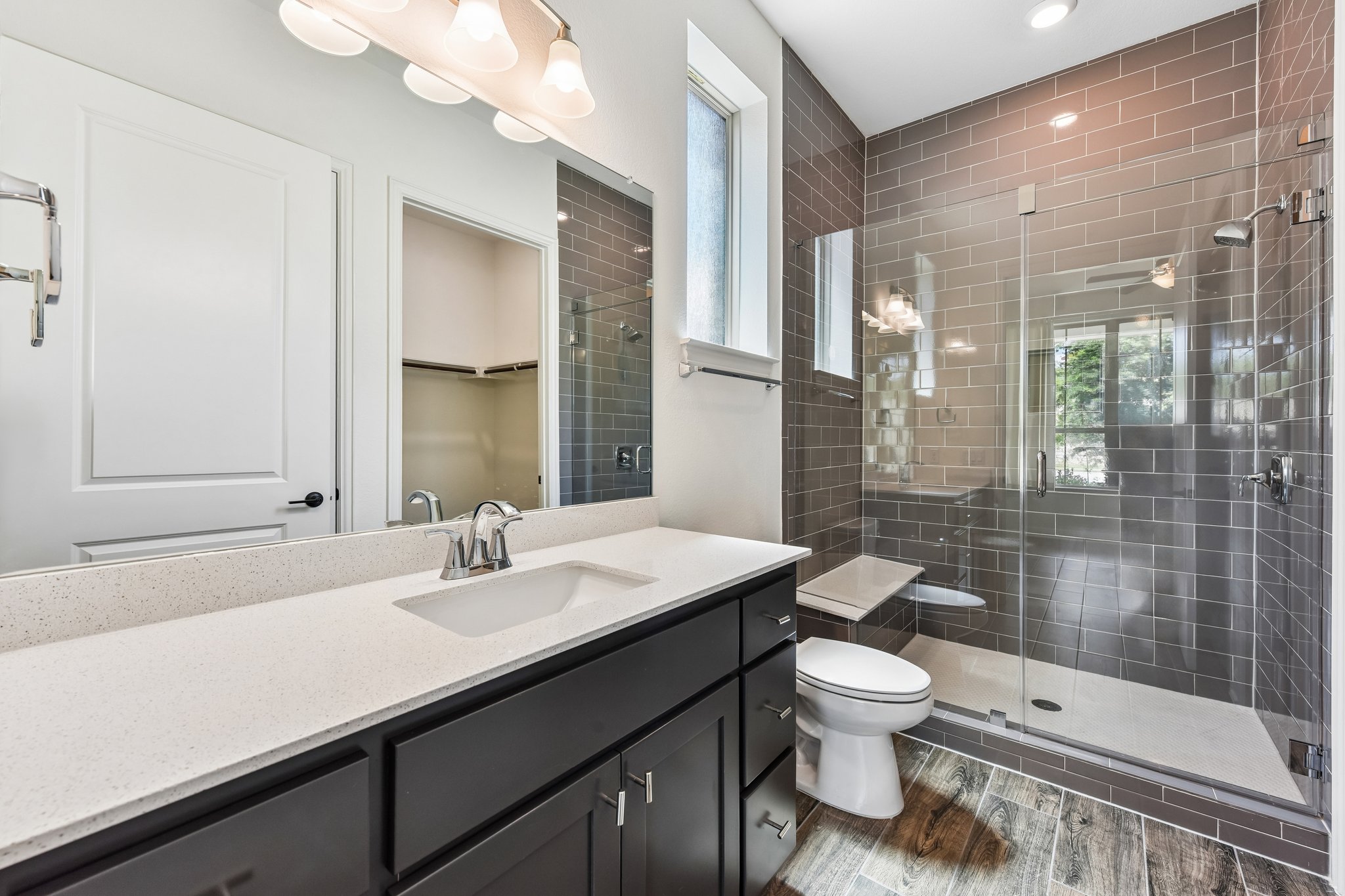 19113 Freeman Circle Austin, TX 78738 - Photo 19 of 37 A well-appointed bathroom features a modern vanity with a single sink and a spacious glass-enclosed shower.