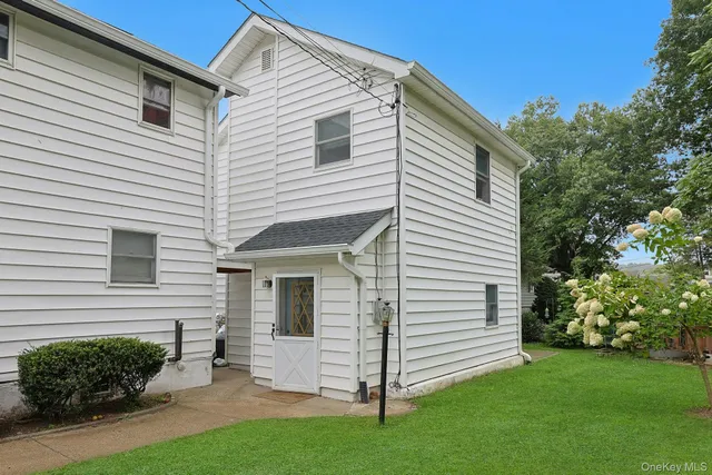 a view of a white house next to a yard