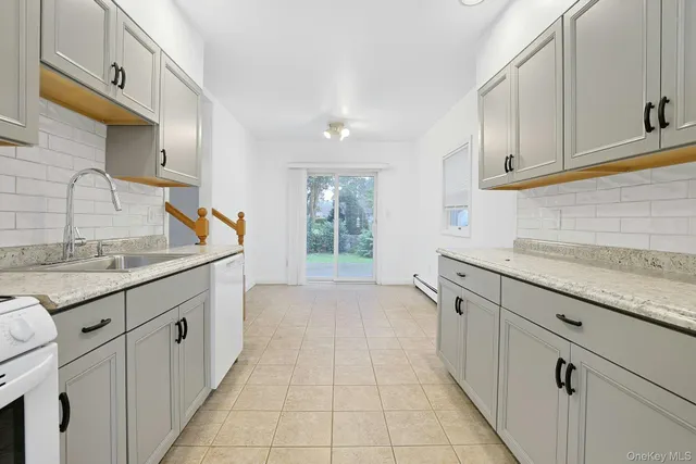 a kitchen with granite countertop white cabinets and sink