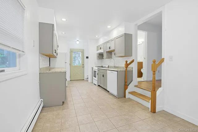 a kitchen with white cabinets and refrigerator