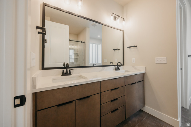 5910 Canyon Rim Road, Unit 619 Lehi, UT 84048 - Photo 37 of 52 Dual vanity with undermount sinks, stone-finish countertop, and wood-finish cabinetry