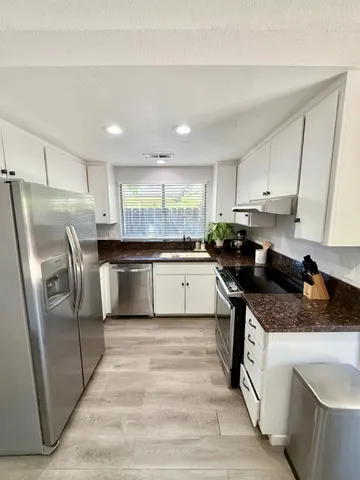 a kitchen with stainless steel appliances granite countertop a stove a sink and a refrigerator