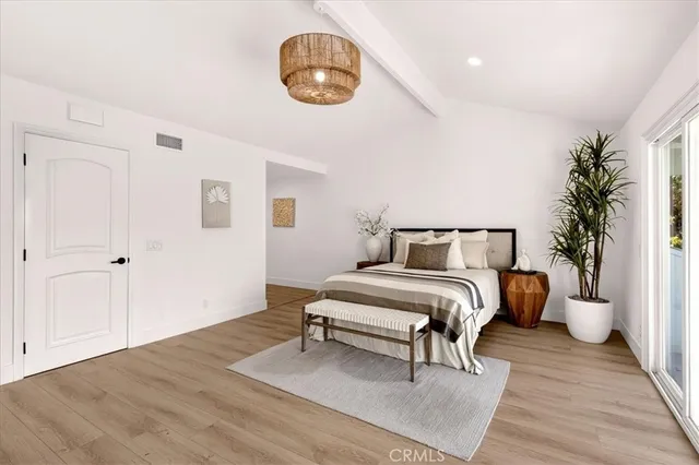 a spacious bedroom with a bed and a chandelier