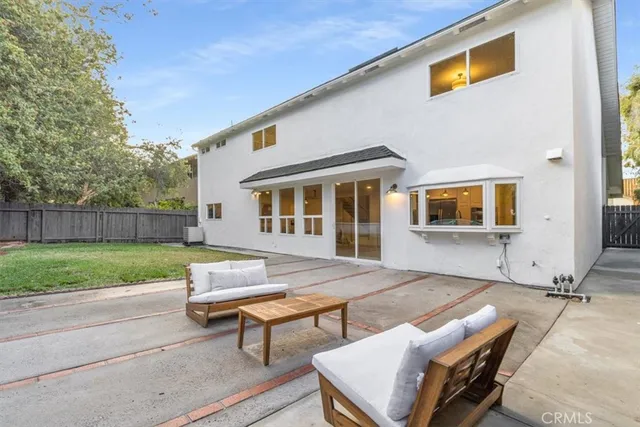 a backyard of a house with table and chairs