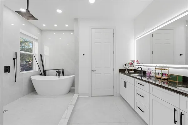 a bathroom with a bathtub sink and mirror