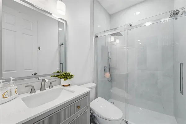 a bathroom with a sink a toilet and shower