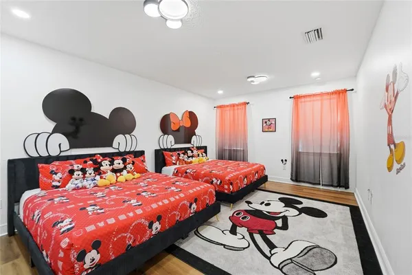 a bed room with two bed and painting on the wall