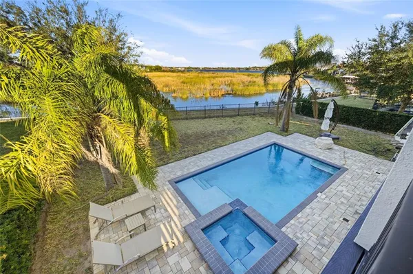 a view of a swimming pool with a lake and trees in the background