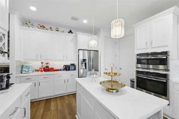 a kitchen with a sink dishwasher a stove and a refrigerator with wooden floor