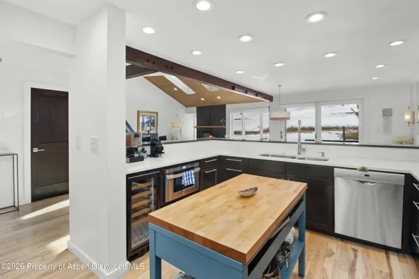 a kitchen with a sink a counter top space and stainless steel appliances