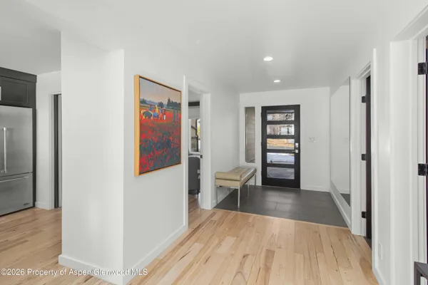 a view of a hallway with wooden floor and dining room