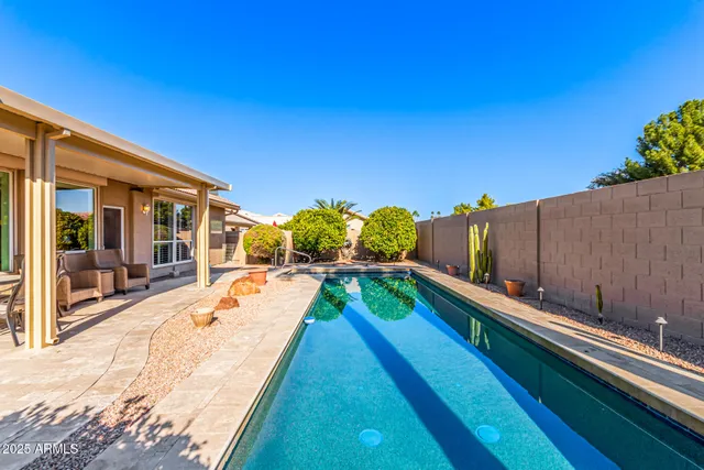 a swimming pool with outdoor seating and yard