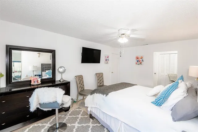 a bedroom with a bed a flat screen tv and couches