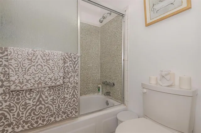 a bathroom with a shower a toilet and a sink