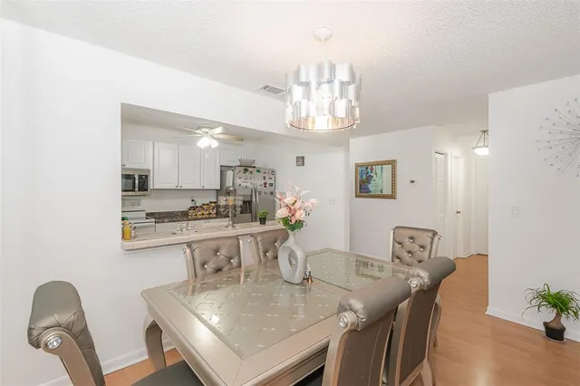 a view of a dining room with furniture a chandelier and wooden floor