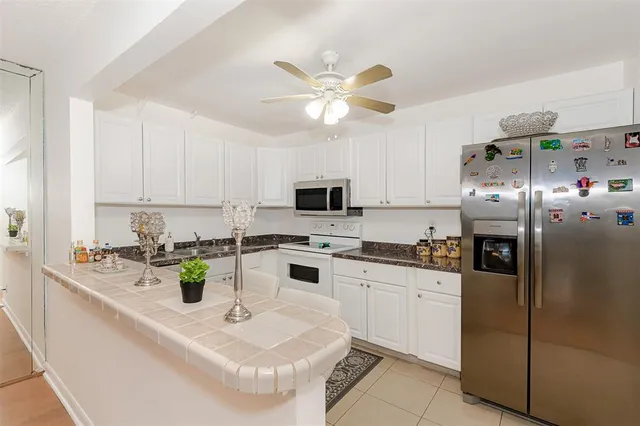 a kitchen with stainless steel appliances granite countertop a sink a stove and a refrigerator