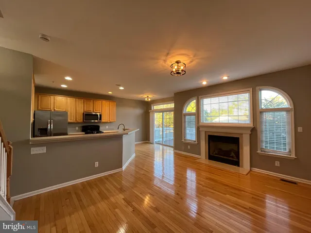 a large kitchen with stainless steel appliances granite countertop a sink and wooden floor