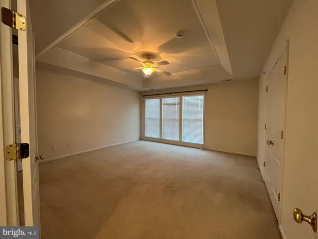 an empty room with a bathroom and a ceiling fan