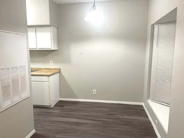 a view of a room with wooden floor and cabinets