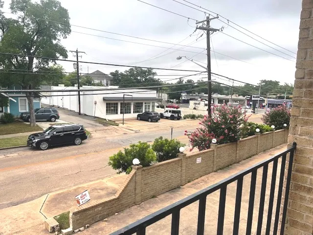 a view of a balcony and car parked on the road