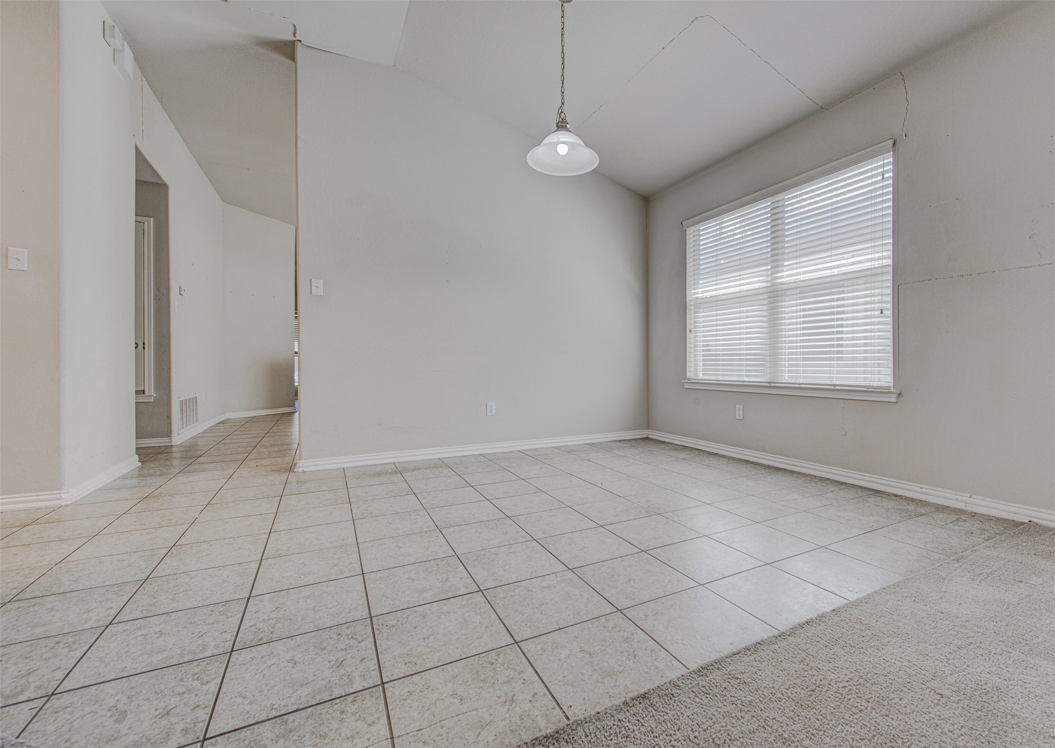 2090 Intrepid Drive Buda, TX 78610 - Photo 10 of 24 Empty room with light tile patterned flooring and lofted ceiling